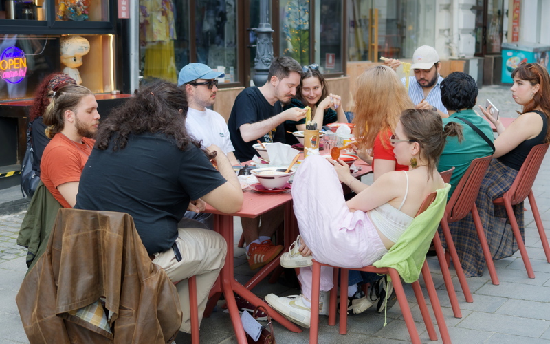 25 - A group of people enjoying a meal at an outdoor restaurant table